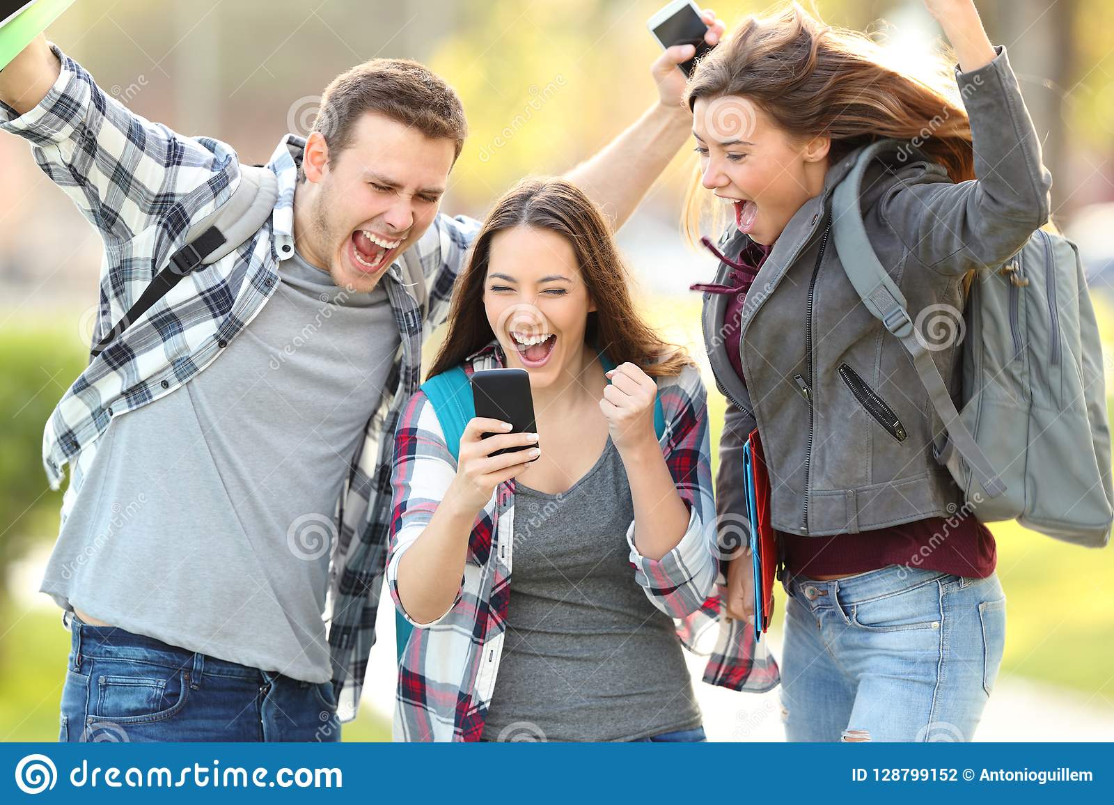 excited-students-checking-exam-grades-online-three-smart-phone-128799152.jpg